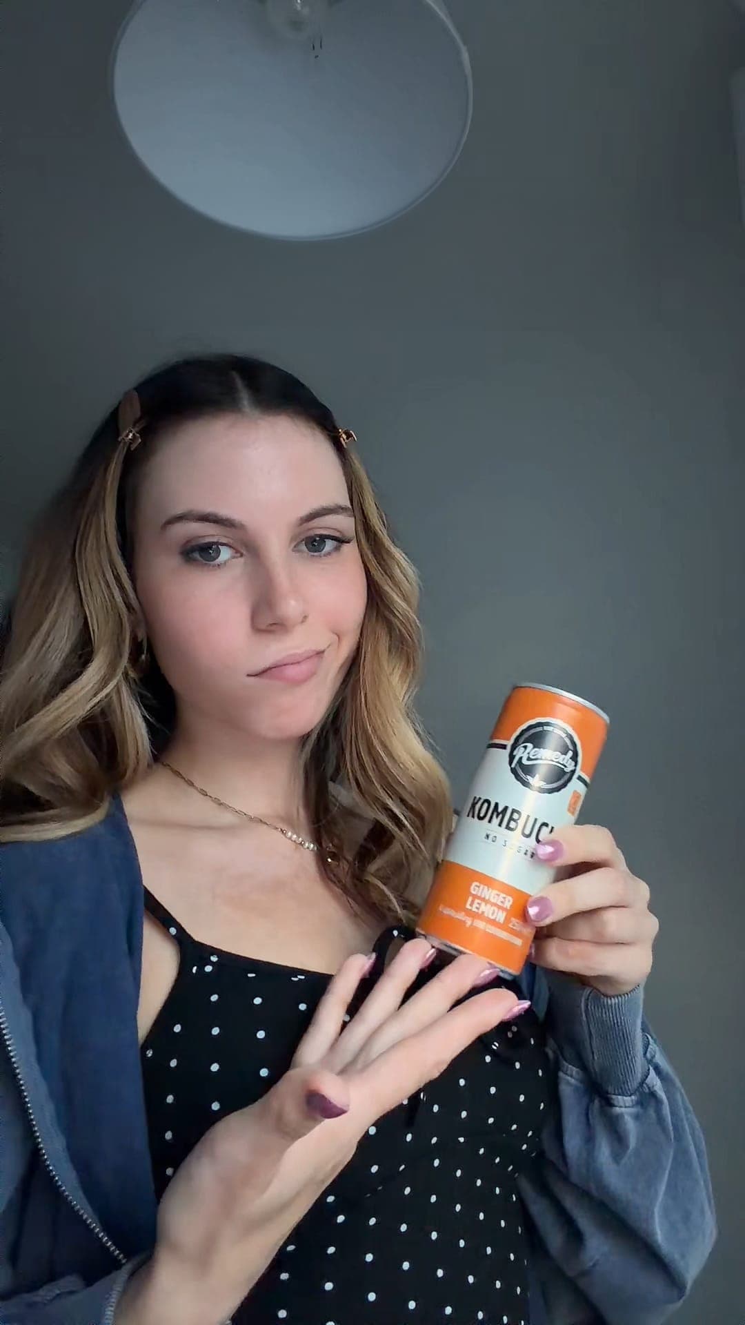 A creator holding a can of Remedy kombucha to camera