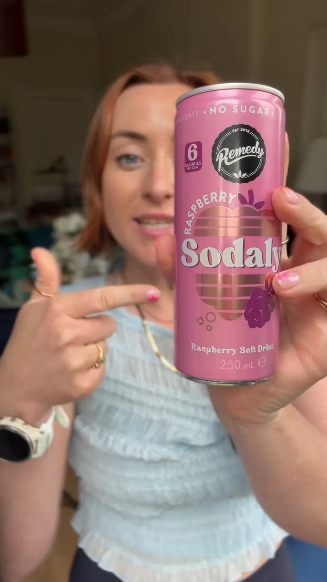 A creator pointing to a can of Remedy Raspberry Sodaly