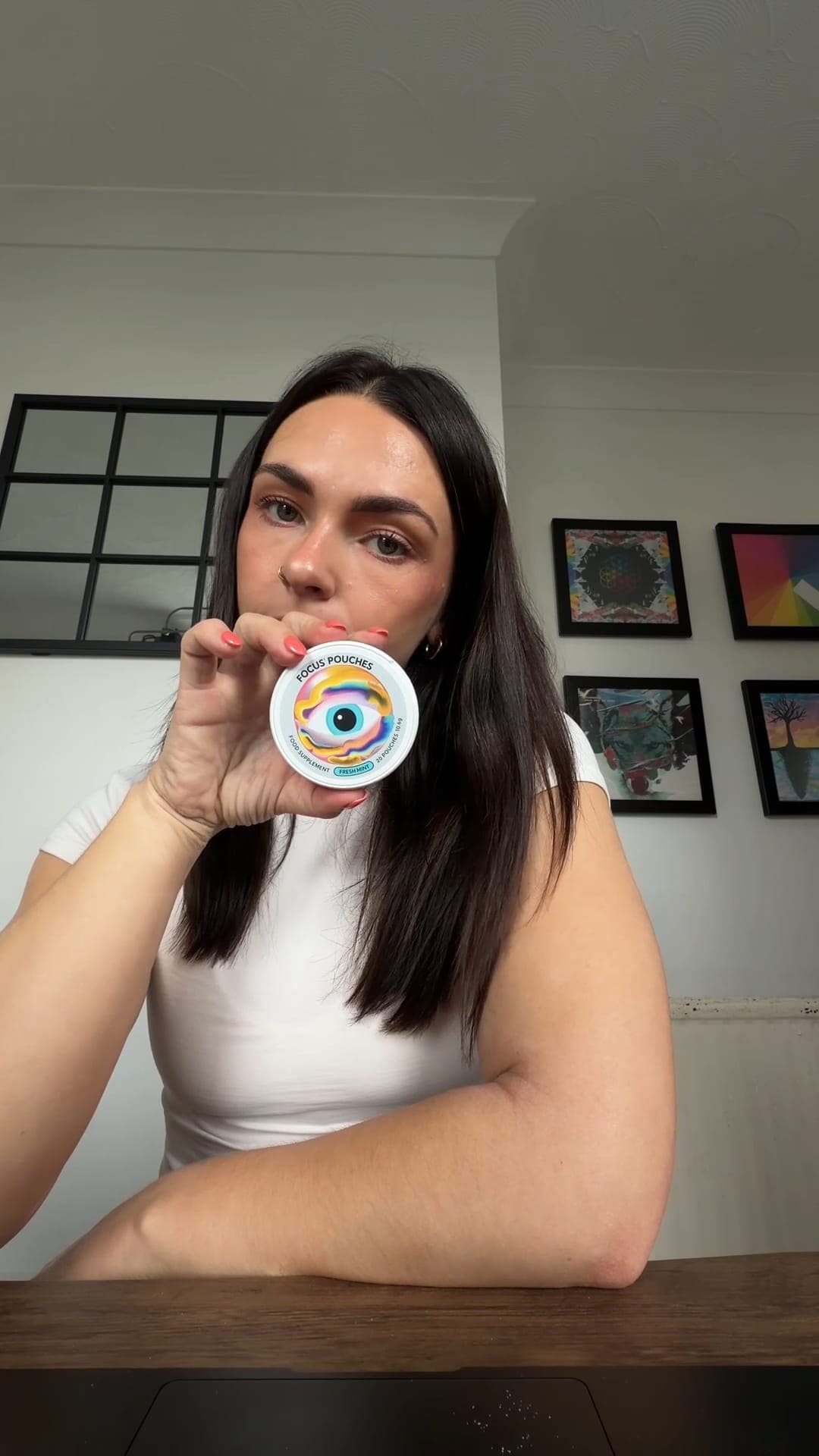 A creator at home holding up a tin of Focus Pouches